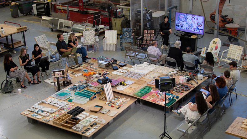 Researchers discuss AI-driven polymer discovery in a materials lab workshop.