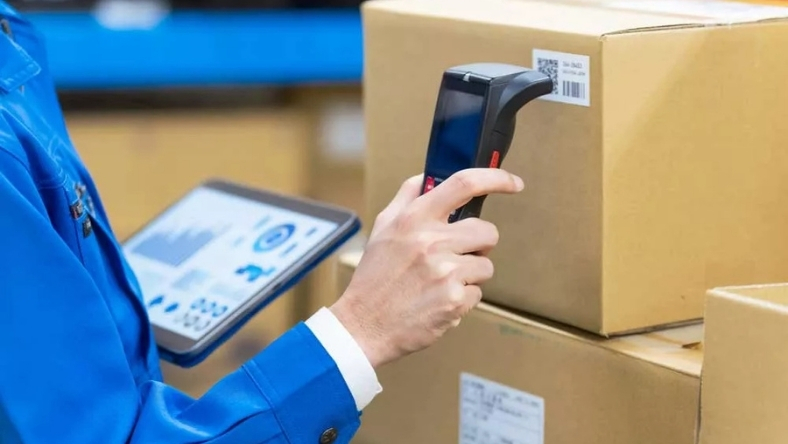 Worker scanning RFID label on packaged food box using handheld reader