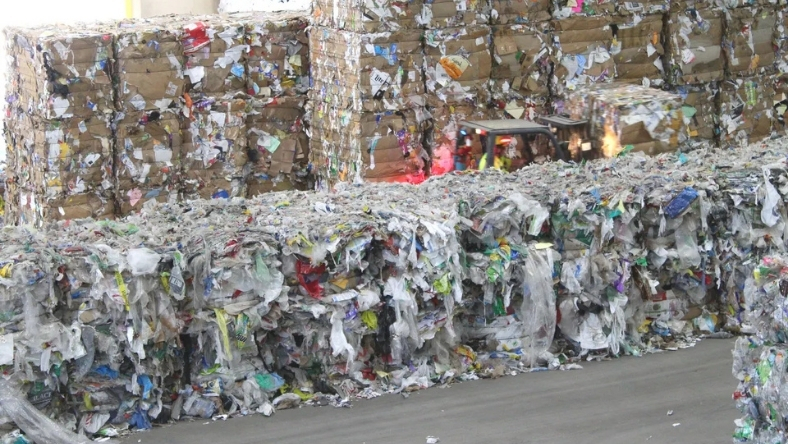 Compressed bales of plastic film waste stacked at recycling facility